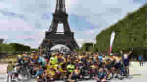 Riders celebrating in front of the Eiffel Tower